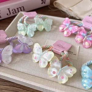 Détail d'élastiques papillon aux tons pastel et couleurs macarons sur un plateau