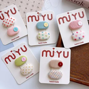 Close-up of handmade polka dot and checkered fabric hair clips set on display cards