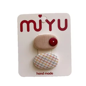 Set of two sweet polka dot and checkered oval hair clips for children on white card