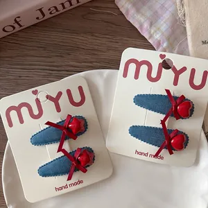 Détail de barrettes en denim bleu faites à la main avec étoile et cœur sur carton