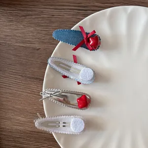 Détail de quatre barrettes pour enfants avec étoiles rouges, nœuds et textures denim