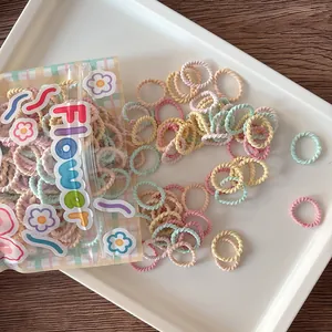 Close-up of candy color elastic hair ties with spiral texture in a flower-themed bag