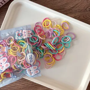 Detail of colorful spiral hair ties in a cute rabbit themed bag on a white tray