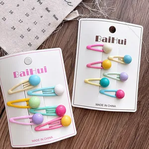 Detail of colorful macaron bead hair clips set on a rustic wooden background