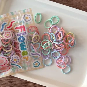 Macro view of macaron colored spiral hair ties with floral themed packaging