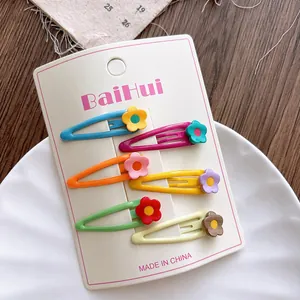Detailed view of six colorful floral hair clips on a white display card packaging