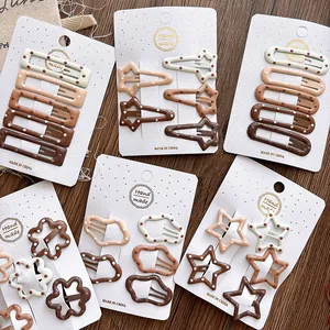 Detail of five cream and coffee gradient polka dot hair clips on a handmade card display