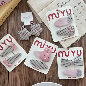 Detailed set of handmade pink and grey fabric bow hair clips and rabbit ties for girls