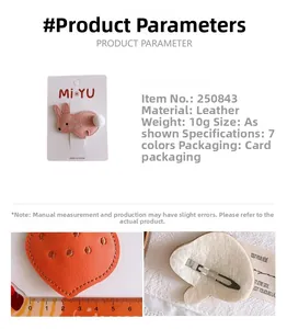 Detail view of pink rabbit and orange strawberry leather hair clips with size measurement