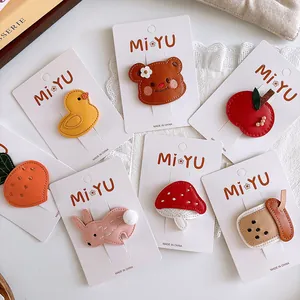 Close-up of cute cartoon embroidered leather hair clips for girls in various animal shapes