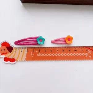 Set of two colorful flower hair clips for girls with measurement scale on white background