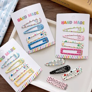 Detailed close-up of colorful patterned snap hair clips on handmade display cards