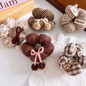 Detail shot of five brown plaid and floral scrunchies with cute bear and rabbit patches