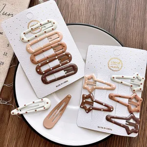 Brown gradient polka dot hair clip set for girls on a card in a white ceramic dish