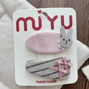 Detail of pink flocked bunny hair clip and striped bow accessories for girls