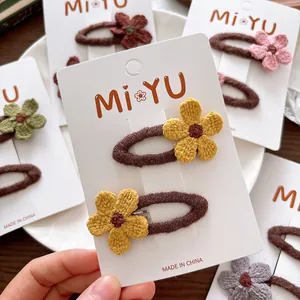 Handmade knitted flower hair clips for children featuring soft fabric texture and colorful petals