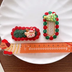 Knitted Christmas hair clips with reindeer and tree patterns for girls on ceramic plate