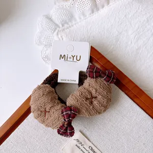 Detail view of brown croissant fabric scrunchies and plaid bows on a card