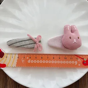 Pink and grey bow clip set with plush bunny hairpin on a white decorative plate