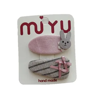 Pink velvet rabbit hair clip and striped bow set for girls on a white display card