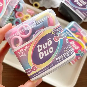 Nahaufnahme bunter Macaron-farbener Kinder-Haargummis in einer klaren Aufbewahrungsbox