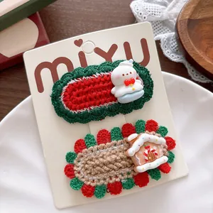 Close-up of handmade crochet Christmas hair clips with snowman and gingerbread house