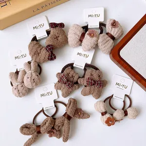 Detailed view of plush bear and bunny hair ties in warm brown tones for girls