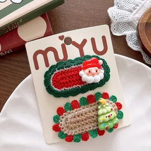 Detail of knitted Christmas hair clips set with Santa and Xmas tree on a display card