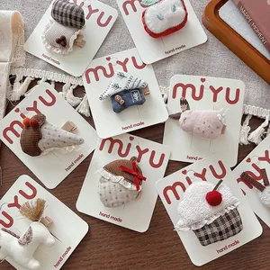 Detail of handmade cute mushroom and bunny cloth hair clips on a white card display