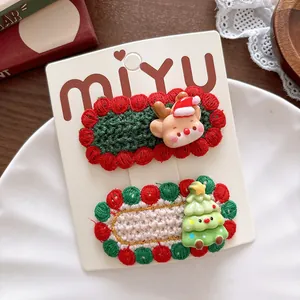 Detail of knitted Christmas hair clips featuring cute reindeer and festive tree charms