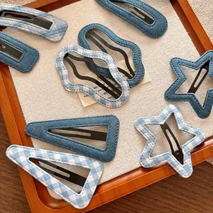 Detailed close-up of blue gingham and denim fabric hair clips in various geometric shapes