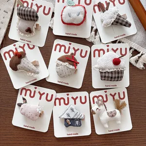 Detail of handmade fabric hair clips with cute mushroom and apple shapes on card