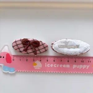 Barrettes à cheveux à carreaux roses avec nœud brodé et règle sur fond blanc