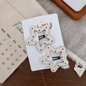 Détail de barrettes en forme d'étoile avec pois rouges sur cuir blanc de haute qualité