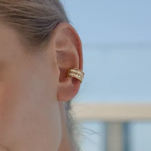 Gros plan d'un ear cuff en acier inoxydable doré avec zircons carrés sans perçage