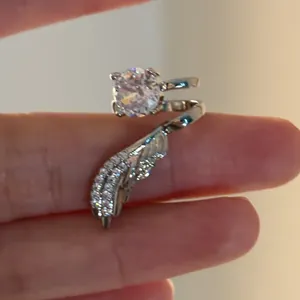 Nahaufnahme eines funkelnden Zirkon-Engelsflügel-Ohrclips ohne Piercing-Design