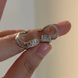 Nahaufnahme von silbernen Engelsflügel-Ohrklemmen mit Zirkonia für Ohren ohne Löcher