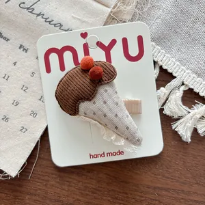 Detailed macro of handmade mushroom hair clip with corduroy and polka dot patterns