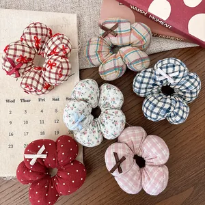 Close-up of floral fabric scrunchies in plaid and polka dot patterns with bow details