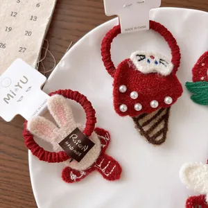 Set di elastici per capelli in maglia rossa con coniglietto e perle su un piatto bianco