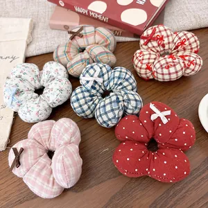 Close-up of six assorted floral pattern scrunchies with polka dots and checks on wood