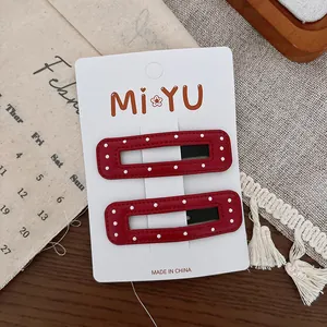 Détail de barrettes à pois rouges sur une carte sur fond en bois avec un décor chaleureux