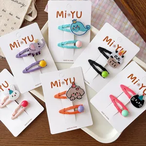 Detailed view of kids BB hair clips with embroidered animals on white display cards