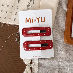 Détail de barrettes rouges à pois pour filles présentées sur carte décorative