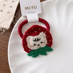 Dettaglio di un elastico per capelli a maglia gatto fragola rosso con ricamo gatto bianco