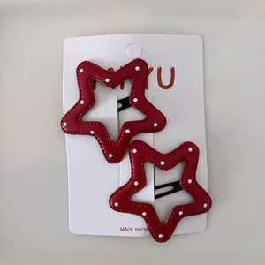Barrettes étoile rouges à pois blancs en similicuir présentées sur carte d'affichage
