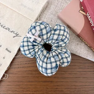 Detail of blue plaid floral scrunchie with pink bow on a rustic wooden background