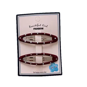 Set di due fermagli per capelli ovali bordeaux a pois su scheda di confezione rosa