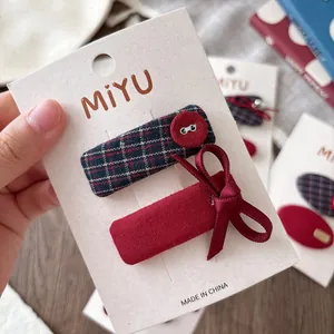 Set di fermagli per capelli a quadretti blu e fiocco rosso per bambine su carta
