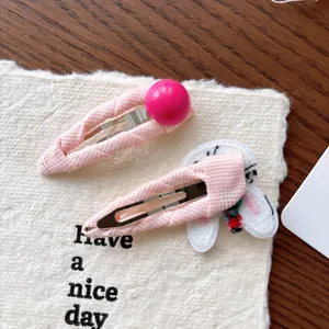 Detail of pink fabric covered BB hair clips with embroidered bunny and bead accents